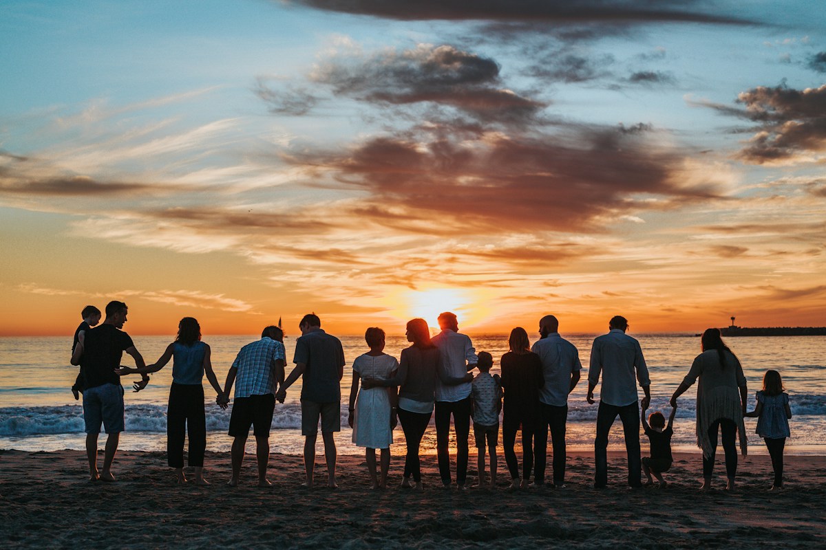 A family holding hands on the beach at sunset